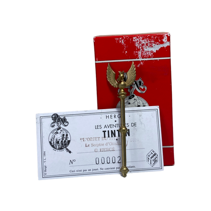 Sceptre d’Ottokar en or et rouge, avec détails décoratifs, présenté sur fond blanc, par Espace714.