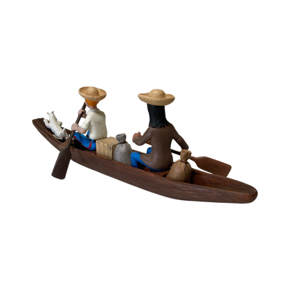 Petite pirogue en bois avec Tintin, l’Indien et Milou, illustrant une scène de bande dessinée.
