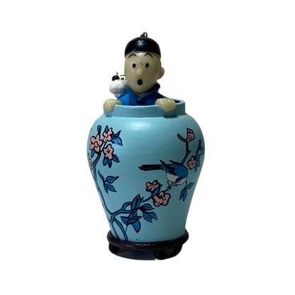 Porte-clé Tintin et Milou dans une potiche, illustré par Hergé, en métal avec détail coloré, pour collection ou décoration.