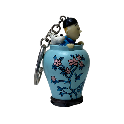 Porte-clé Tintin et Milou dans une potiche, illustration d'Hergé représentant le personnage de Tintin, accessoire de collection.